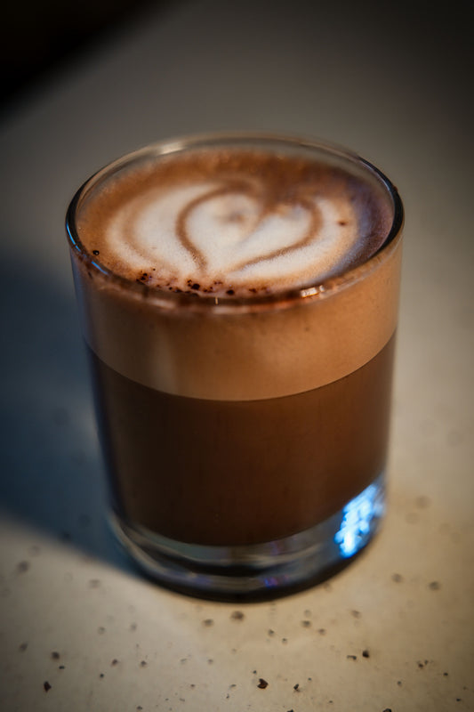 A rich, creamy latte in a cosy home café setting — the base for a pistachio latte recipe made with pistachio cream