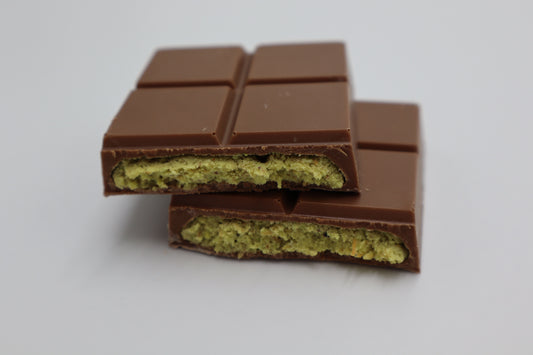 Close-up cross-section of a chocolate bar with thick pistachio filling, showing what an authentic Dubai chocolate bar looks like inside