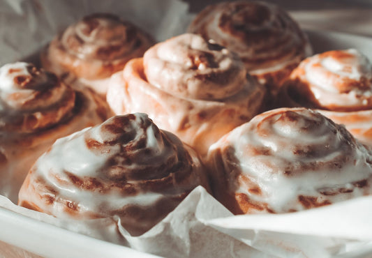 Freshly baked cinnamon rolls with glossy icing, close up — the base for a pistachio cinnamon rolls recipe made with pistachio cream