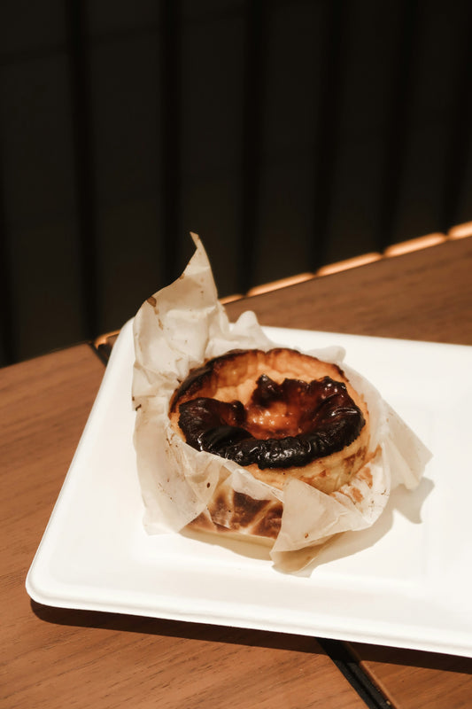Pistachio kunafa cheesecake with a scorched Basque burnt top on parchment paper
