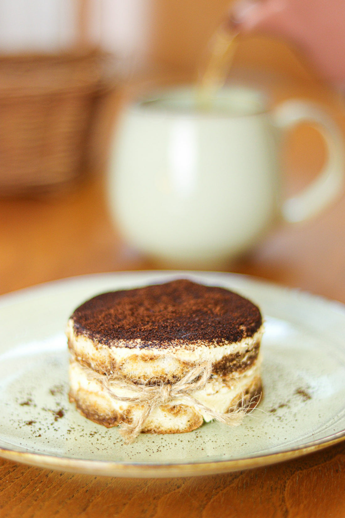 Layered pistachio tiramisu dessert on a white plate — the viral dessert trend of 2026